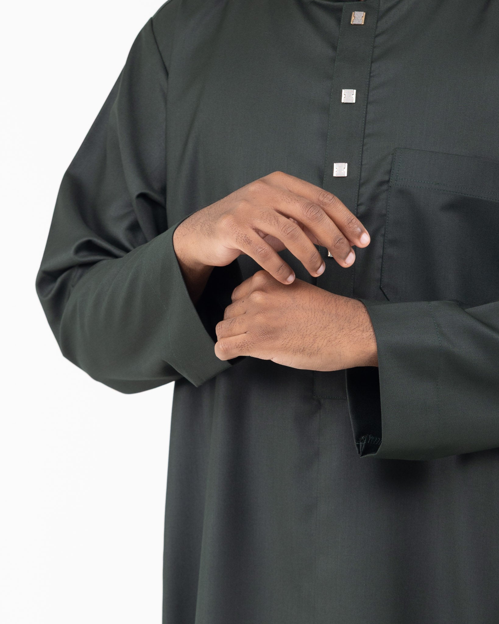 Sleeve close up details of a man wearing a green long collared thobe with buttoned sleeves.